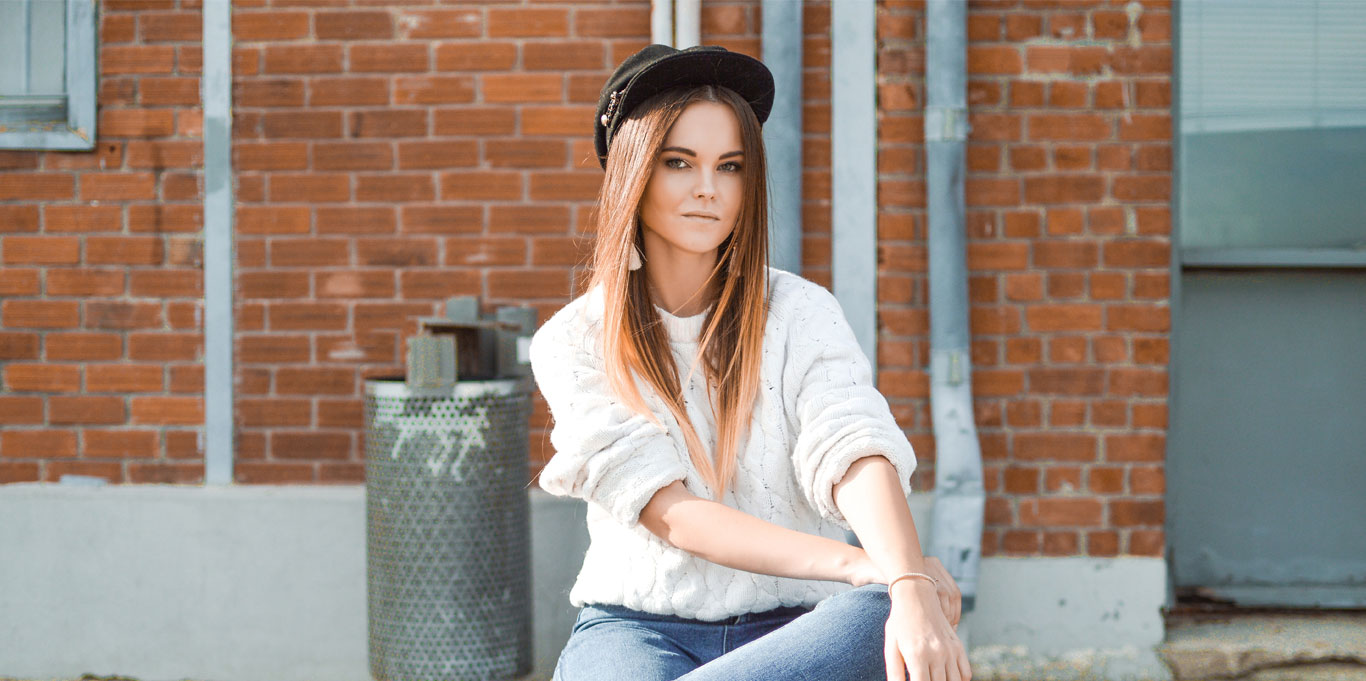 Sally sits in front of a building