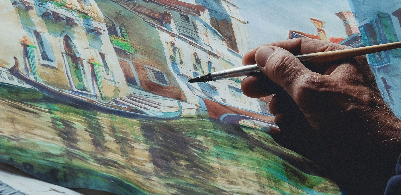 Close-up of artist painting a riverside watercolour scene.