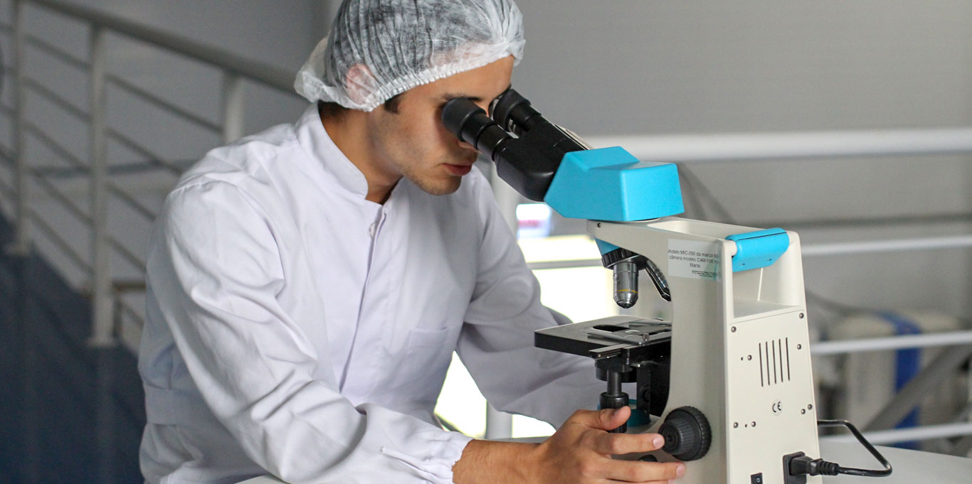 Medical researcher looking through a microscope