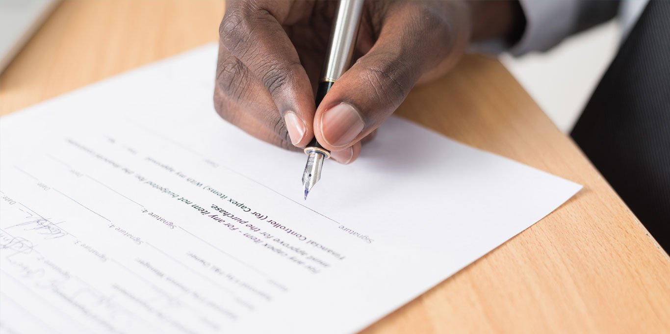 A male hand signs a contract