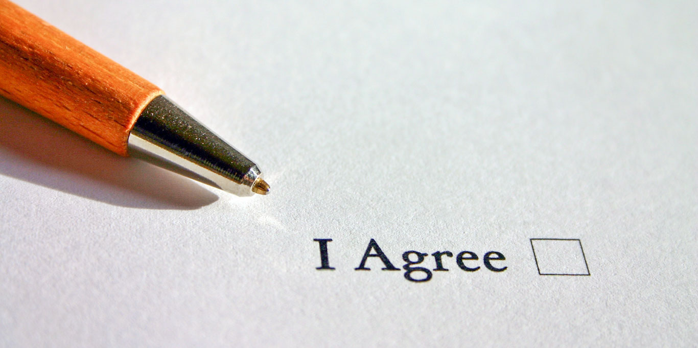 Contract with the words ‘I agree’ next to a checkbox; a pen lies on the contract.