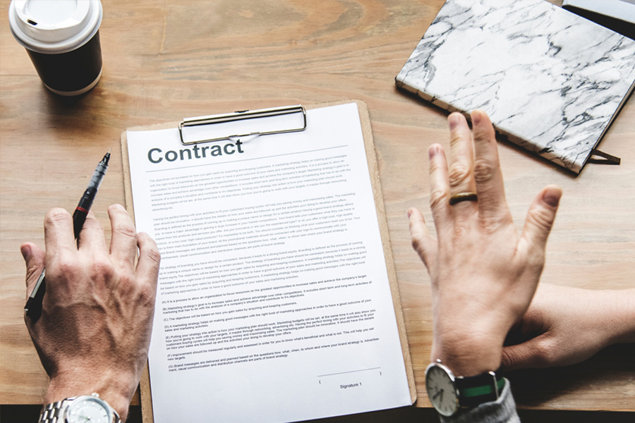 Two people negotiating a written contract over coffee