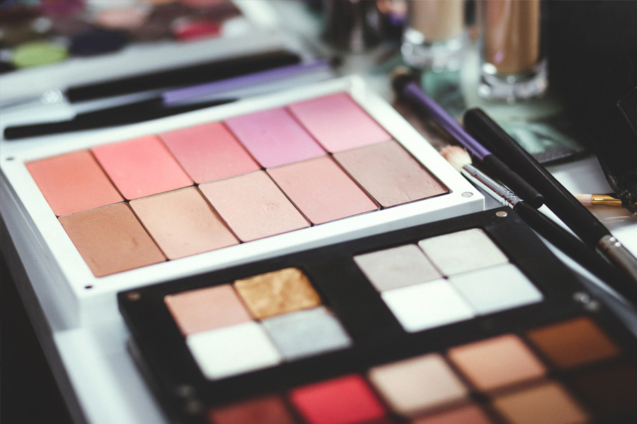 Trays of eyeshadow and blush and makeup applicator brushes