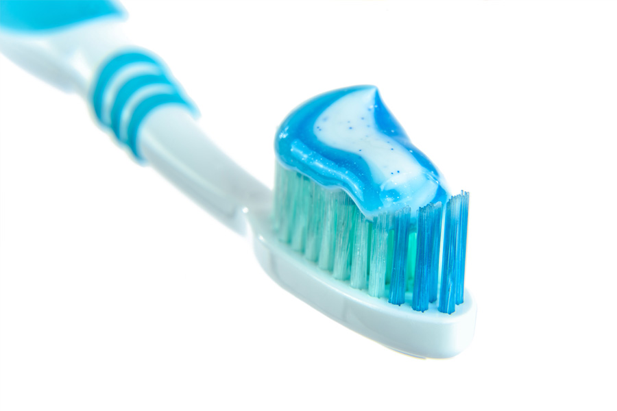 Blue and white toothpaste on toothbrush.