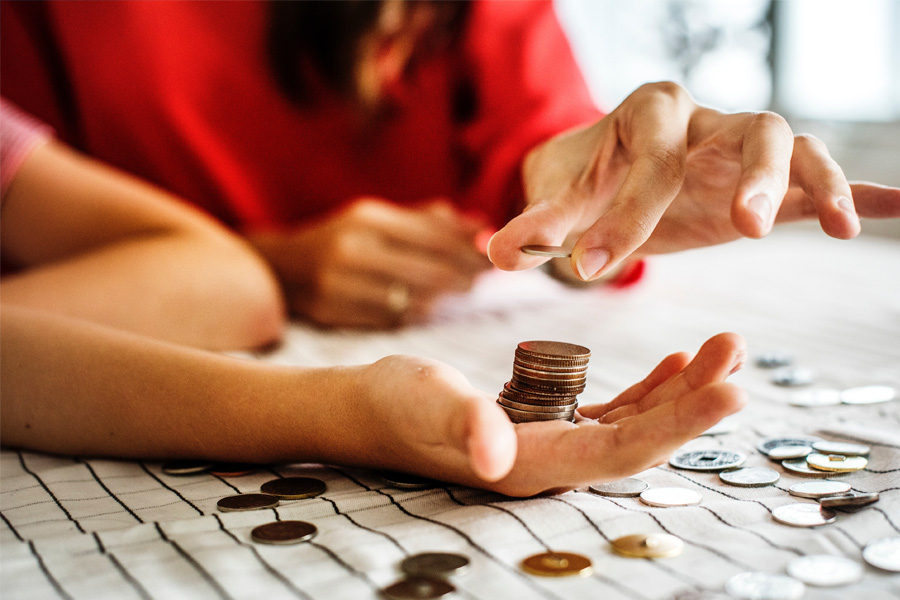 Person places coins in a stack into another person’s open hand